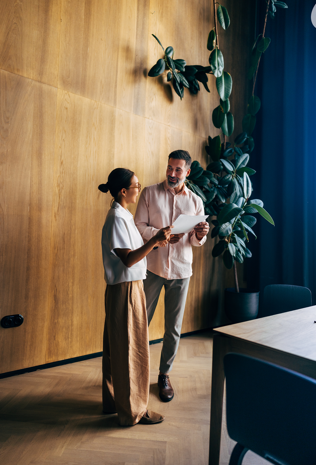 Two colleagues discussing business information in a modern workplace setting.